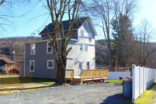 view of side of property featuring a lawn and a deck