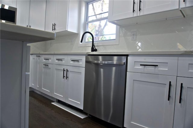 kitchen with white cabinets, backsplash, stainless steel appliances, and dark wood-type flooring