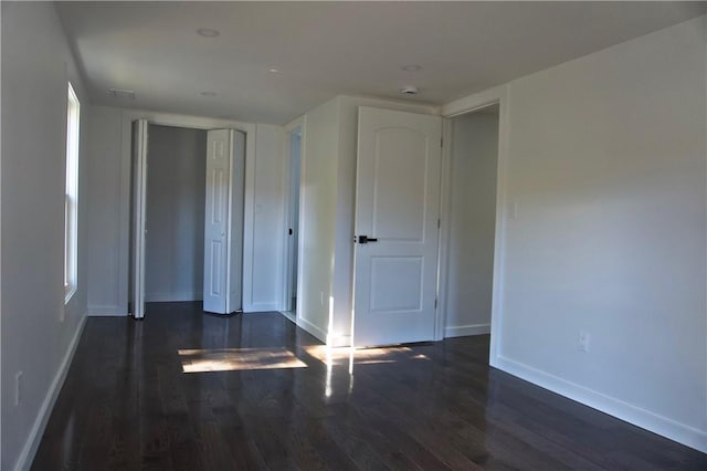 unfurnished bedroom featuring dark hardwood / wood-style floors and a closet