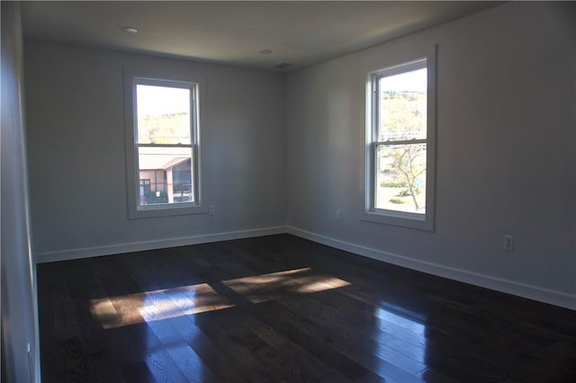 unfurnished room featuring dark hardwood / wood-style flooring and a wealth of natural light