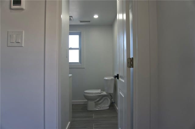 bathroom featuring hardwood / wood-style flooring and toilet