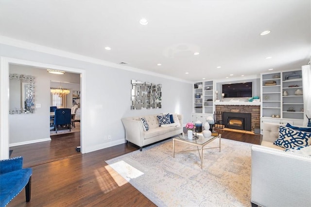 living room with a stone fireplace, crown molding, and dark hardwood / wood-style floors