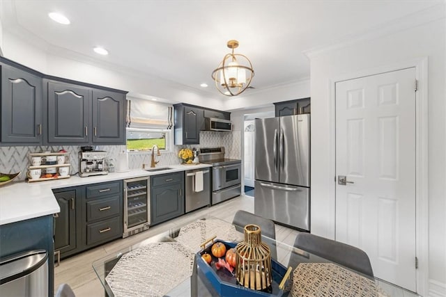 kitchen featuring sink, hanging light fixtures, beverage cooler, decorative backsplash, and appliances with stainless steel finishes