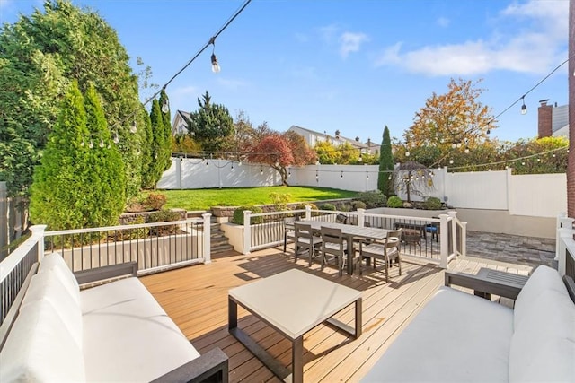 deck with an outdoor living space and a yard