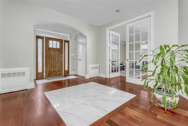 foyer featuring wood-type flooring and radiator heating unit