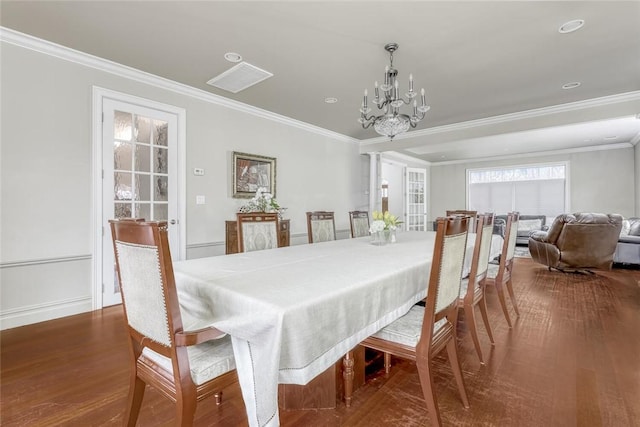 dining room featuring crown molding, dark hardwood / wood-style floors, and a notable chandelier