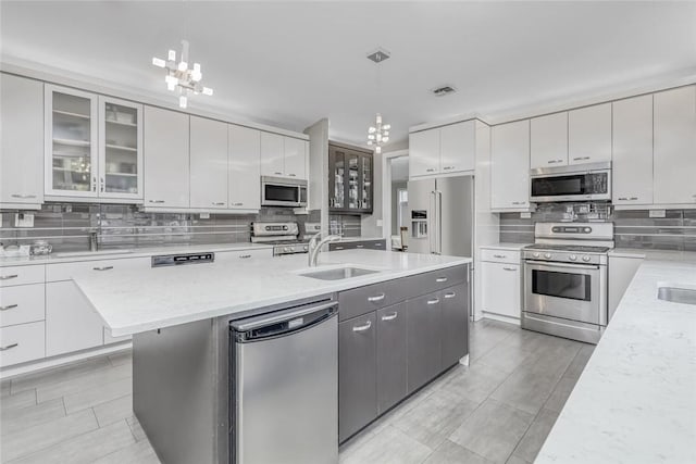 kitchen featuring decorative light fixtures, white cabinetry, and appliances with stainless steel finishes