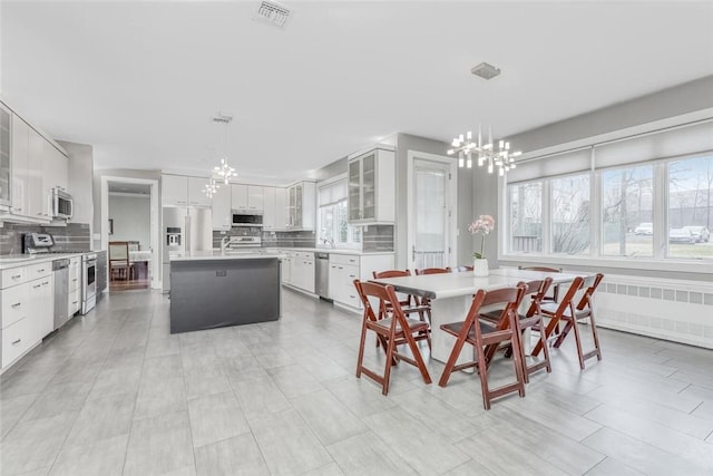 tiled dining room featuring a wealth of natural light, sink, and a chandelier