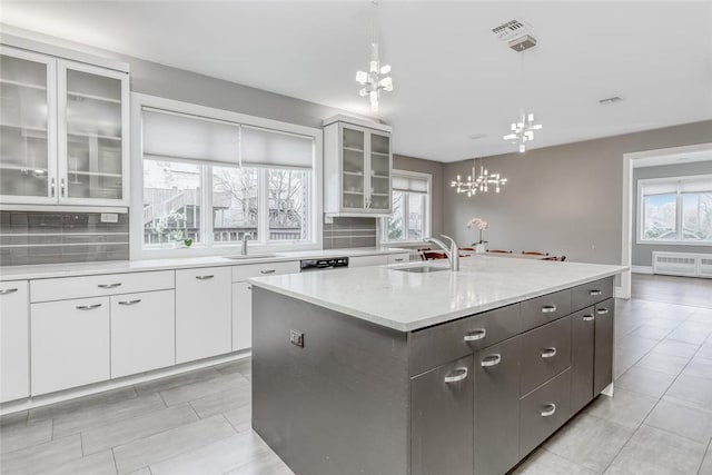 kitchen with a center island with sink, white cabinetry, a wealth of natural light, and sink