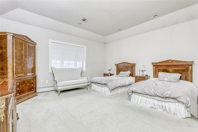 carpeted bedroom with a tray ceiling and a baseboard heating unit