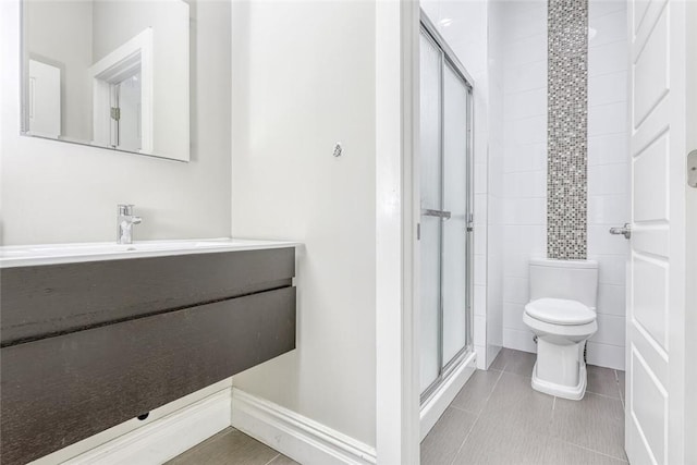 bathroom with tile patterned floors, vanity, toilet, and walk in shower