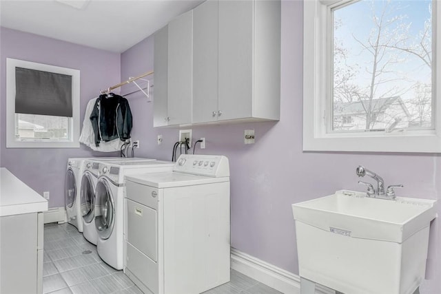 laundry area featuring cabinets, washer and dryer, and sink