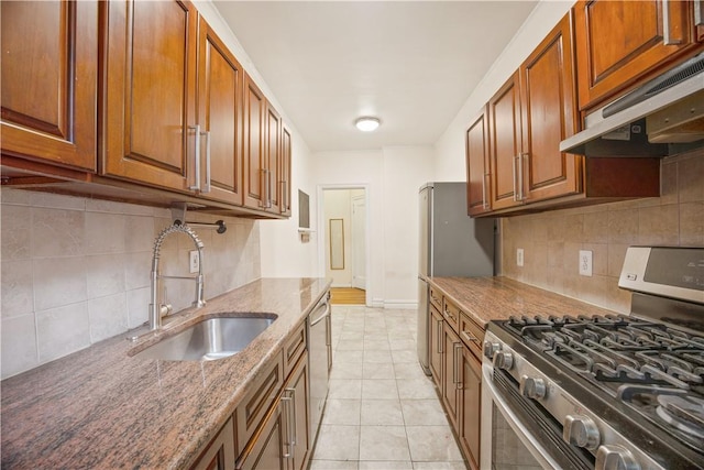 kitchen with sink, tasteful backsplash, dark stone countertops, extractor fan, and appliances with stainless steel finishes