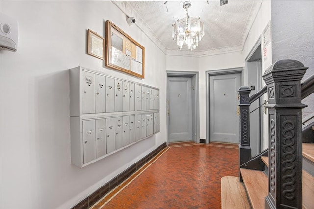 foyer featuring mail boxes, crown molding, and an inviting chandelier