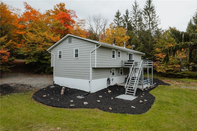 rear view of house with a lawn and a deck