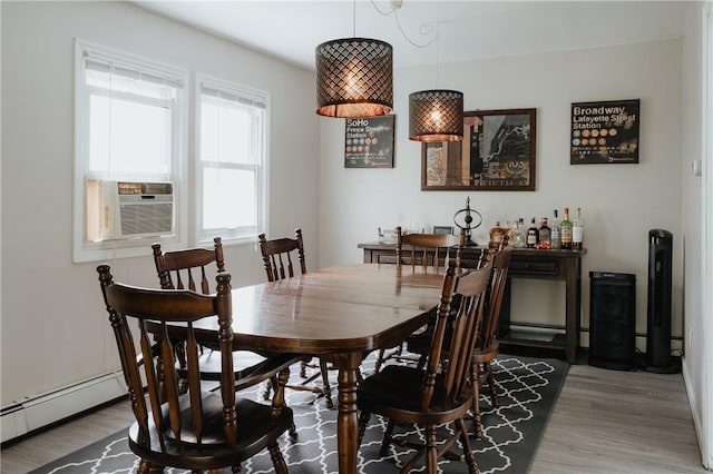 dining area featuring hardwood / wood-style floors, cooling unit, and a baseboard radiator