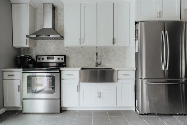 kitchen with white cabinets, wall chimney range hood, sink, and appliances with stainless steel finishes