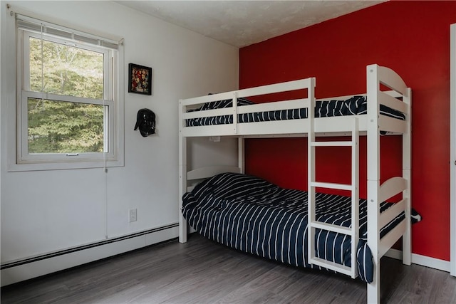 bedroom with multiple windows, dark hardwood / wood-style flooring, and a baseboard radiator