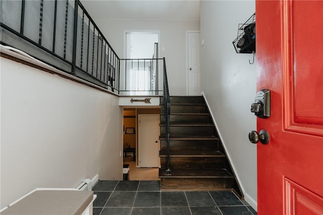 staircase featuring tile patterned floors and a baseboard heating unit