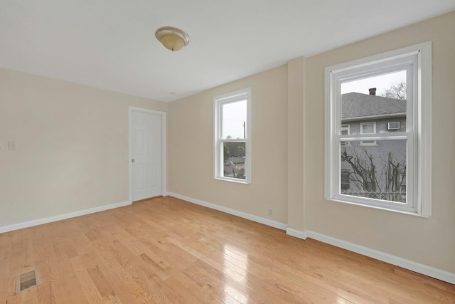 spare room featuring light hardwood / wood-style flooring and a healthy amount of sunlight