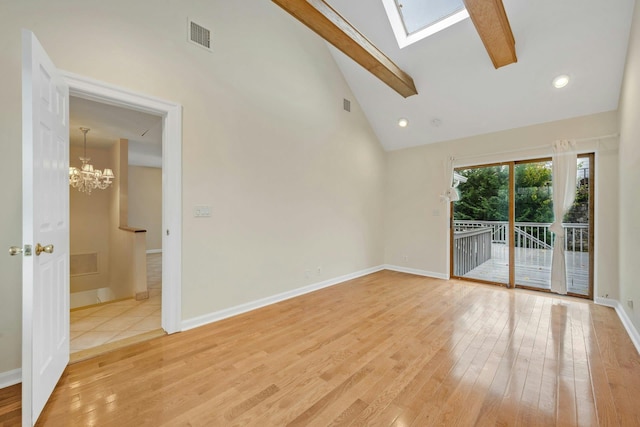 empty room featuring hardwood / wood-style floors, high vaulted ceiling, a skylight, beamed ceiling, and a chandelier