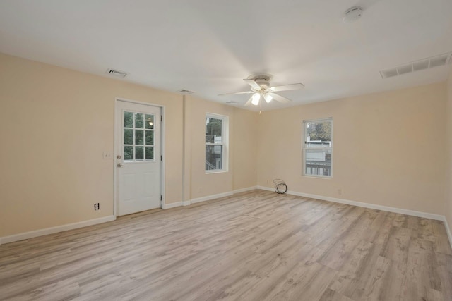 empty room with ceiling fan and light hardwood / wood-style flooring