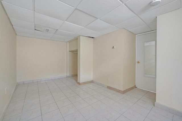 tiled spare room with a drop ceiling