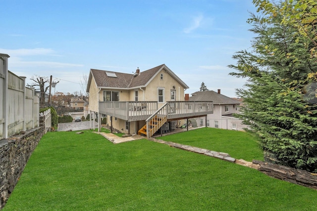 rear view of property featuring a lawn and a wooden deck