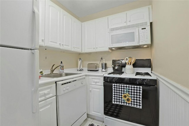 kitchen with sink, white cabinets, white appliances, and light tile patterned floors