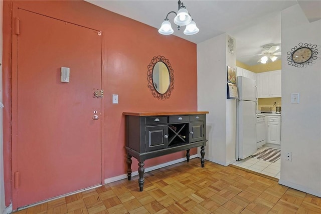 interior space featuring light parquet floors and ceiling fan with notable chandelier