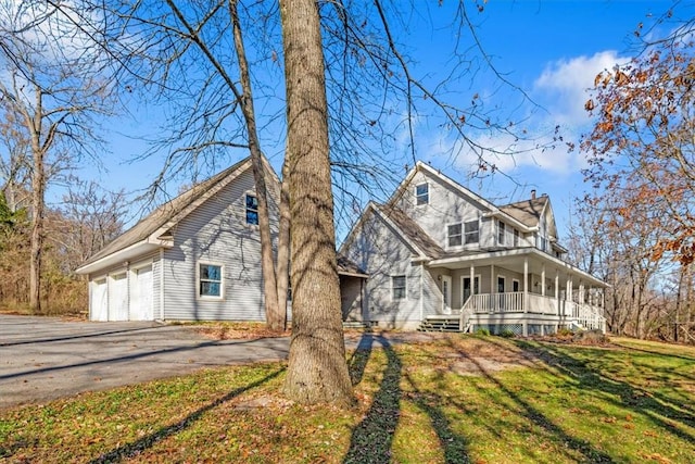 view of front of house with a garage, a porch, and a front yard