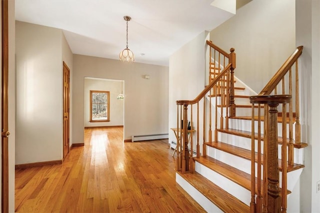 interior space featuring a baseboard radiator, a notable chandelier, and light wood-type flooring