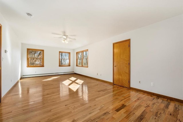 spare room with ceiling fan, light wood-type flooring, and a baseboard radiator