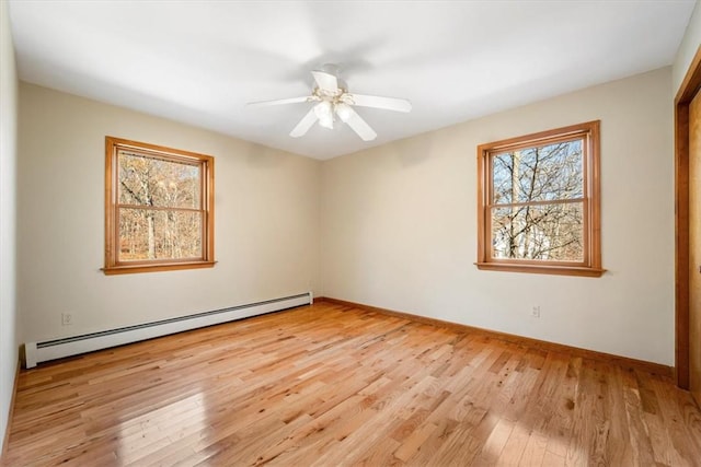 unfurnished room featuring baseboard heating, ceiling fan, plenty of natural light, and light wood-type flooring