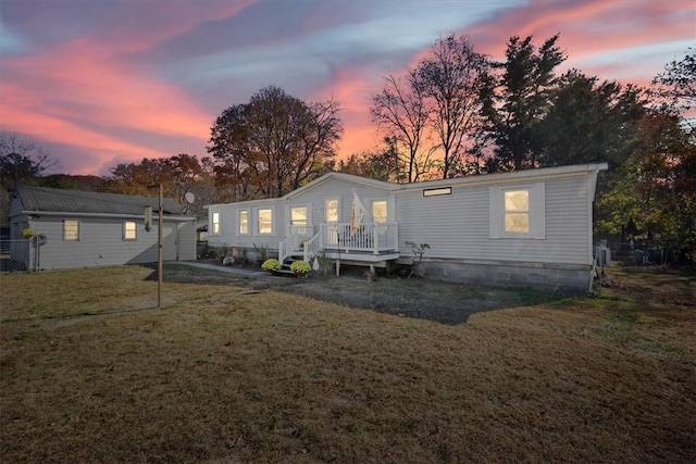 back house at dusk featuring a yard