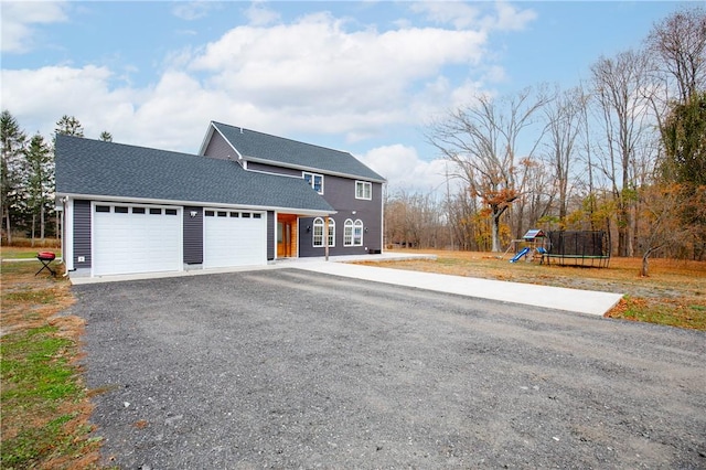 view of front of property with a playground, a garage, and a trampoline