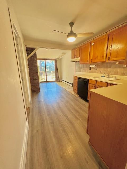 kitchen featuring sink, black dishwasher, a baseboard heating unit, backsplash, and light hardwood / wood-style floors