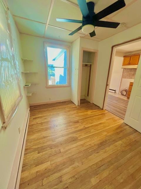 unfurnished bedroom featuring ceiling fan, light hardwood / wood-style floors, and a baseboard radiator