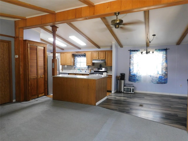 kitchen featuring ceiling fan with notable chandelier, a kitchen island, vaulted ceiling with beams, dark hardwood / wood-style floors, and stainless steel range with gas cooktop