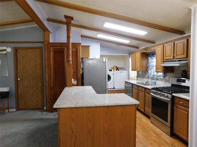 kitchen featuring a center island, lofted ceiling with beams, sink, stainless steel appliances, and washing machine and clothes dryer