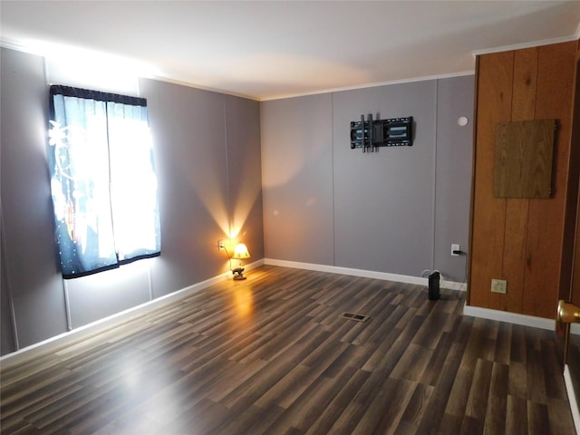 spare room with crown molding, dark hardwood / wood-style flooring, and a healthy amount of sunlight