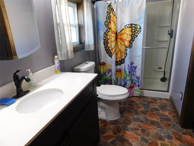 bathroom featuring a shower with shower curtain, vanity, and toilet