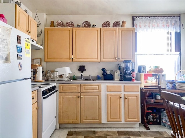 kitchen with light brown cabinetry and white appliances