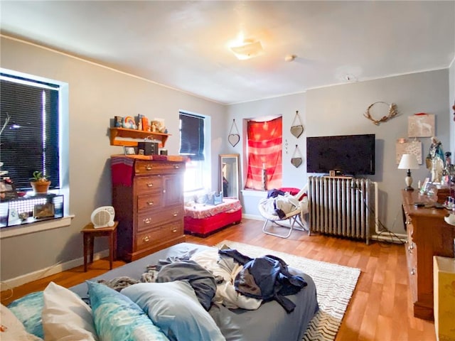 bedroom featuring light wood-type flooring and radiator