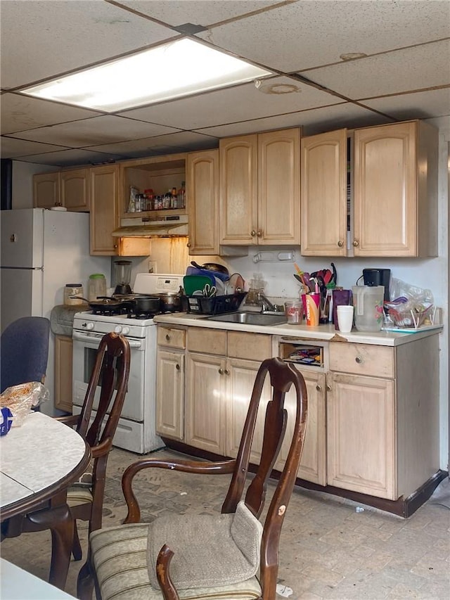 kitchen featuring sink, a drop ceiling, white appliances, and light brown cabinets