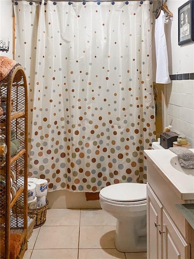 bathroom with a shower with curtain, vanity, tile walls, tile patterned flooring, and toilet