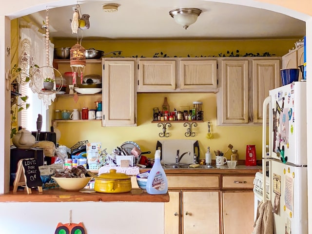 kitchen with light brown cabinetry, white appliances, butcher block countertops, and sink