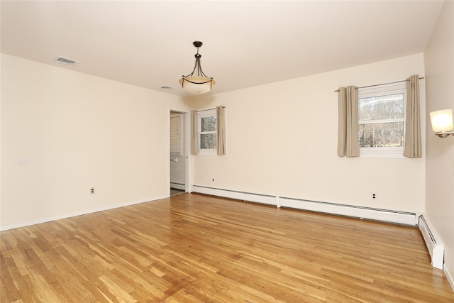 empty room featuring light hardwood / wood-style flooring and a baseboard heating unit