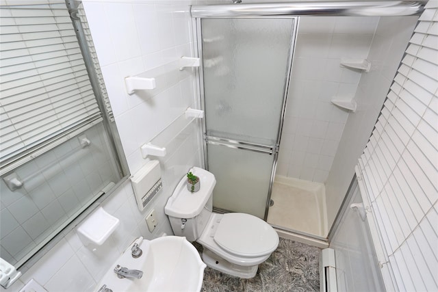 bathroom featuring toilet, a shower with door, tile walls, and a baseboard heating unit