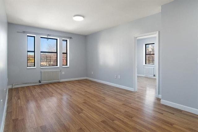 spare room featuring hardwood / wood-style floors and radiator